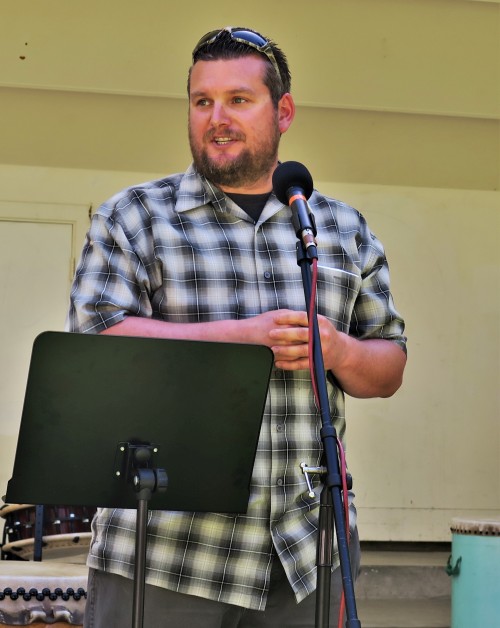 Mike Oxendine stands on stage speaking into a microphone